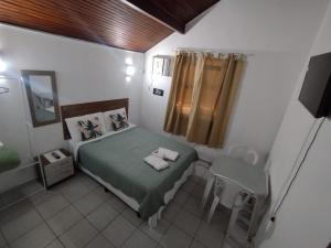 a small bedroom with a bed and a mirror at Vale do Pontal Angra in Angra dos Reis