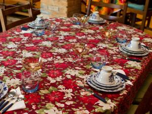 uma mesa com uma toalha de mesa vermelha e branca com pratos e copos em Hospedaria Os Memorialistas - Paranapiacaba em Paranapiacaba