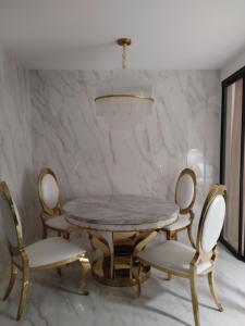 a dining room with a marble table and chairs at Apartament Lipowa 2 in Mrągowo