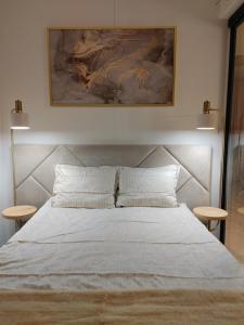 a bedroom with a large white bed with two tables at Apartament Lipowa 2 in Mrągowo
