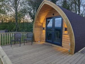 einen Pavillon mit zwei Stühlen auf einer Holzterrasse in der Unterkunft Ashberry Glamping in York