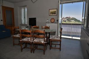a dining room with a table and chairs and a window at A CASA DI ANNA in La Morra