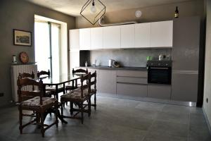 ラ・モッラにあるA CASA DI ANNAのテーブルと椅子のあるキッチンと白いキャビネットのあるキッチン