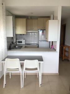 a kitchen with two chairs and a table and a refrigerator at La Tortuguita in San Blas