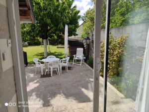 a patio with a table and chairs in a yard at Studio Les Tilleuls in Amboise