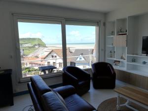 a living room with a couch and chairs and a large window at Au Bigorneau Langoureux in Criel-sur-Mer