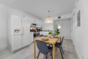 uma cozinha com uma mesa e cadeiras e um frigorífico branco em Splendid Location Apt close to Brickell & Marlins Park em Miami