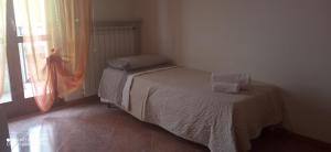 Habitación pequeña con cama y ventana en Garda View Apartment, en Cavalcaselle
