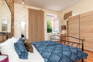 a bedroom with a bed with a blue comforter and a window at Heisenberg City Residence in Pula