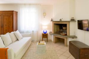 a living room with a white couch and a fireplace at Casa vacanze San Vittorino in Gubbio