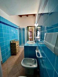 bagno blu con lavandino e servizi igienici di Villa Antonella a San Teodoro