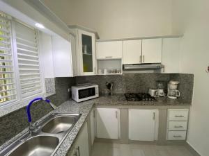 a kitchen with a sink and a microwave at Caribbean Villa Los Lobos Ballenas Beach in Las Terrenas