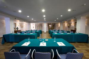 Una sala de conferencias con mesas y sillas azules. en Parador de Ribadeo, en Ribadeo