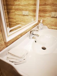 a bathroom sink with a mirror and a towel on it at Ohana House w Juracie in Jurata