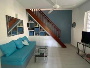 a living room with a blue couch and a staircase at Caribbean Villa Los Lobos Ballenas Beach in Las Terrenas