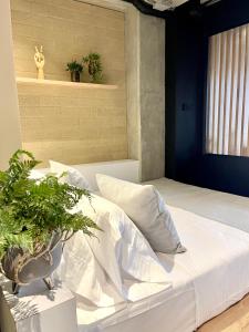 1 dormitorio con cama blanca y macetas en beminimal Hotel en Medellín