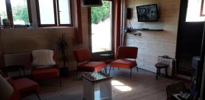 a waiting room with red chairs and a tv at BnB chambres d'hôtes le Chêne in Ban-sur-Meurthe-Clefcy