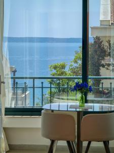 Sole Mio Apartment & Wellness في هرسك نوفي: طاولة وكراسي مطلة على المحيط