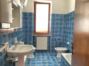 un bagno piastrellato blu con lavandino e WC di Alice a Numana