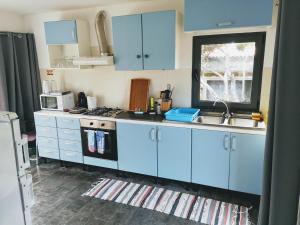a kitchen with blue cabinets and a sink at Retiro dos Bons Sinais in São Roque do Pico