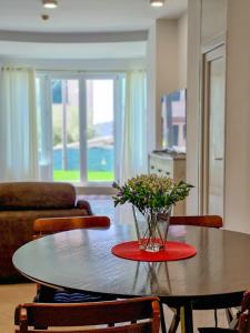 Sole Mio Apartment & Wellness في هرسك نوفي: طاولة غرفة الطعام مع إناء من الزهور عليها