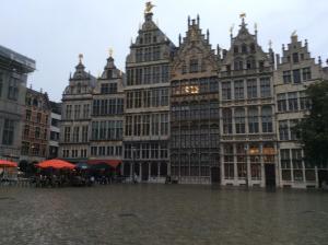 a group of tall buildings in a flooded street at Historical center Antwerp, all on foot in Antwerp