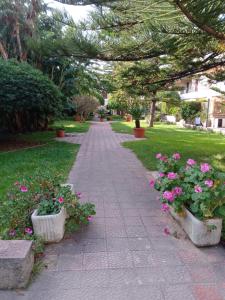 a sidewalk with pink flowers in a park at Casa Vacanze La Tonnara in San Giorgio