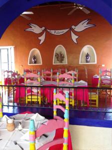 une chambre avec une table et des chaises dans une pièce avec une fête dans l'établissement Hotel Boutique Las Palomas de Santiago Pueblo Mágico, à Santiago