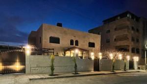 budynek z oświetleniem przed nim w nocy w obiekcie PALM Home w mieście Amman