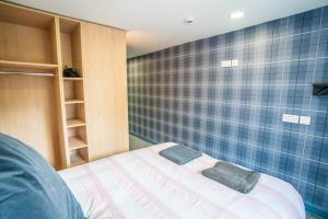 ein Schlafzimmer mit einem Bett und einer blau gefliesten Wand in der Unterkunft Apartment Chinatown 302 in Newcastle upon Tyne