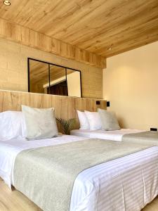two beds sitting next to each other in a bedroom at beminimal Hotel in Medellín