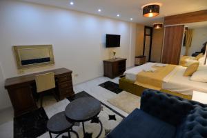 a bedroom with a bed and a desk and a couch at Prenoćište BIS in Prijepolje
