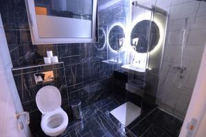 a black tiled bathroom with a toilet and a shower at Prenoćište BIS in Prijepolje +33 photos