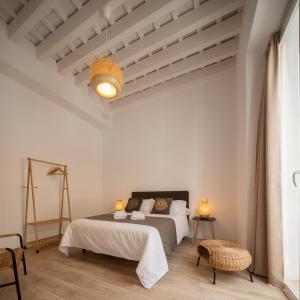 a white bedroom with a bed and a ceiling at La Casa de Lima Little Apartments in Cádiz