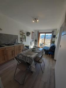 a living room with a table and a kitchen at le refuge de la blanche in Seyne