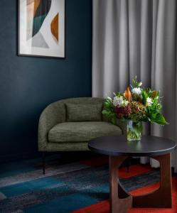 a living room with a vase of flowers on a table at Rydges Auckland in Auckland