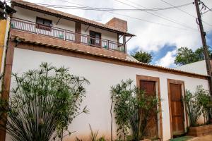 Una casa blanca con un balcón encima. en Casa com WiFi e Piscina perfeita em Camacari BA, en Camassari