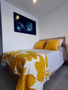 a bedroom with a bed with a yellow and white comforter at Playa Poniente Benidorm in Benidorm