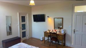 a room with a desk with a mirror and a bed at Geoghegans Magpie Bar and B&B in Glin