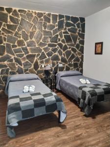 Un dormitorio con dos camas y una pared de piedra. en Alojamientos Rurales La Esperanza, en Arriate 69 fotos más