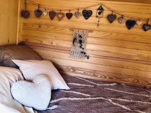a bedroom with a wooden wall with hearts on it at Roulotte La Chouette des Granges in Les Salles-Lavauguyon