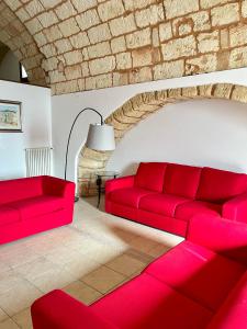 un soggiorno con divani rossi e un muro di mattoni di Il Frantoio a Depressa