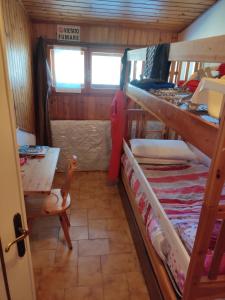 a room with two bunk beds and a table at Stefano Home Abetone in Abetone +3 photos