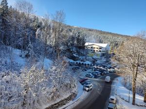una casa en una colina nevada con coches aparcados en una carretera en Stefano Home Abetone, en Abetone