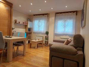un soggiorno con divano e tavolo di Apartamento Vieiro con plaza garaje gratis a Santiago de Compostela