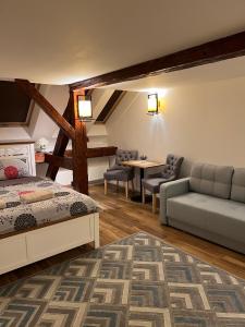 a bedroom with a bed and a couch and a table at KronSoul in Braşov