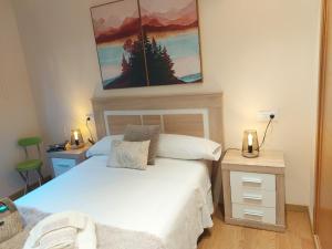 um quarto com duas camas e um quadro na parede em Apartamento Vieiro con plaza garaje gratis em Santiago de Compostela