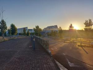 an empty street with the sun setting in the background at Apartamento Vieiro con plaza garaje gratis in Santiago de Compostela