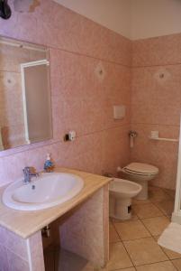 ein Bad mit einem Waschbecken und einem WC in der Unterkunft B&B Al Porto in Marta