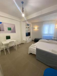 1 dormitorio con 2 camas, mesa y sillas en Il Corallo, en Marettimo